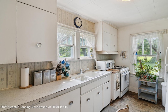 1213 N Woodworth Rd, Jackson, MI 49202 - kitchen featuring white appliances, light countertops, white cabinets, and wallpapered walls