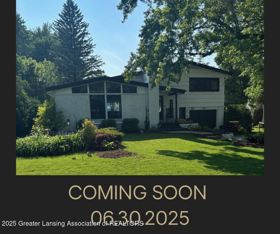 229 Julian Ave, Lansing, MI 48917 - rear view of property with a garage, a yard, and brick siding