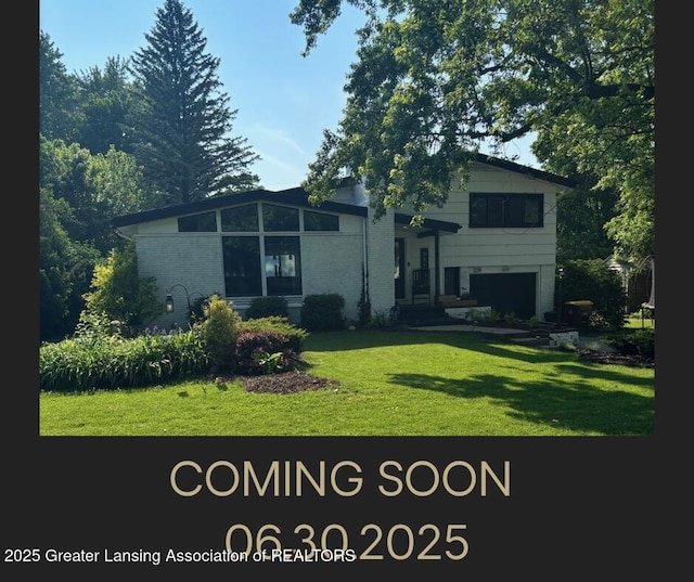 229 Julian Ave, Lansing, MI 48917 - rear view of property with a garage, a yard, and brick siding