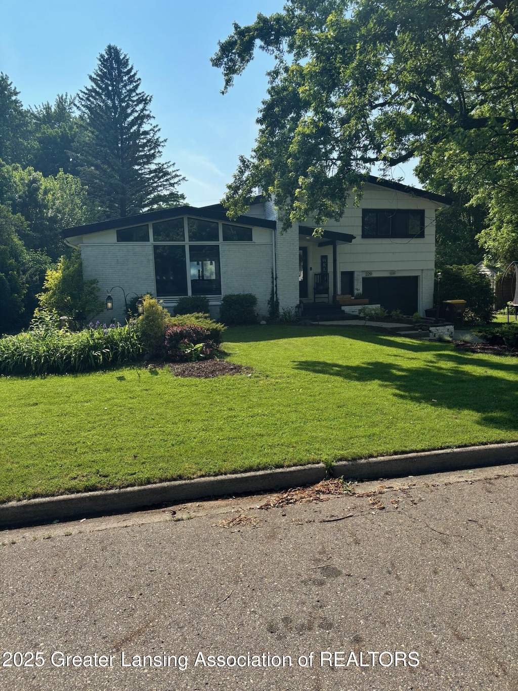 229 Julian Ave, Lansing, MI 48917 - view of front of house featuring a garage and a front lawn