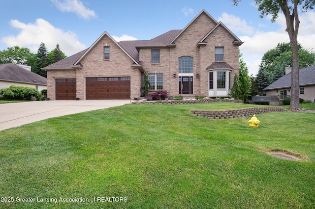 4700 Canyon Trl, Lansing, MI 48917 - traditional-style house featuring driveway, a front lawn, brick siding, and roof with shingles