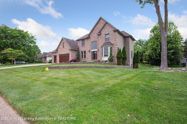 4700 Canyon Trl, Lansing, MI 48917 - traditional home with brick siding, a garage, a front yard, and driveway