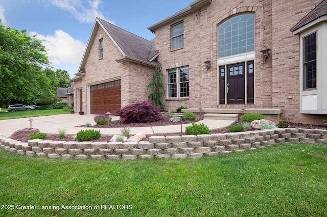 4700 Canyon Trl, Lansing, MI 48917 - view of front of home with brick siding, concrete driveway, a front yard, and roof with shingles