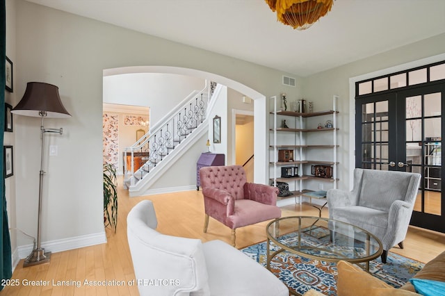 4700 Canyon Trl, Lansing, MI 48917 - living area featuring arched walkways, wood finished floors, stairs, and french doors
