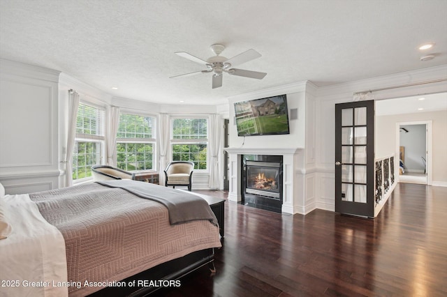 4700 Canyon Trl, Lansing, MI 48917 - bedroom with a decorative wall, wood finished floors, a fireplace with flush hearth, recessed lighting, and crown molding