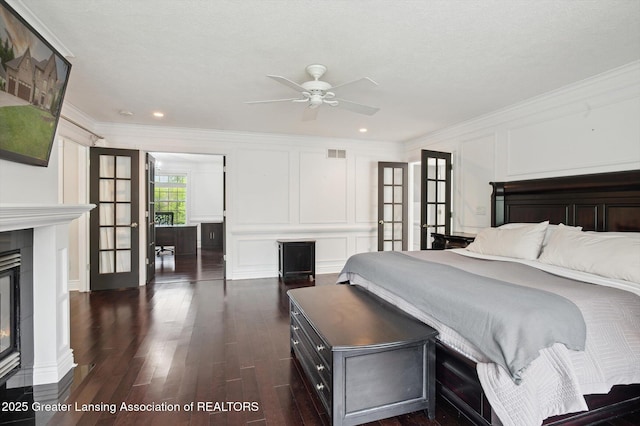 4700 Canyon Trl, Lansing, MI 48917 - bedroom with a decorative wall, ornamental molding, dark wood finished floors, a glass covered fireplace, and recessed lighting