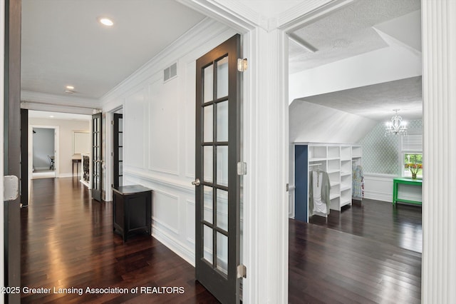 4700 Canyon Trl, Lansing, MI 48917 - hallway featuring a decorative wall, dark wood-style floors, a chandelier, built in features, and ornamental molding