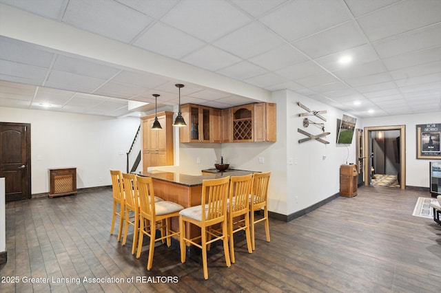 4700 Canyon Trl, Lansing, MI 48917 - dining room featuring bar area, a drop ceiling, and dark wood-style floors