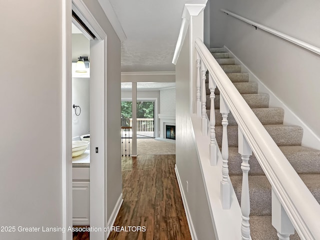 1869 E Burrwood Cir, East Lansing, MI 48823 - stairway with wood finished floors, a fireplace, and crown molding