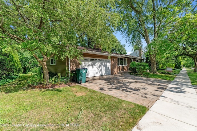 522 Cowley Ave, East Lansing, MI 48823 - view of front of house featuring concrete driveway, a garage, and a front yard