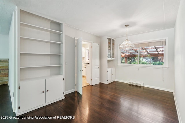 522 Cowley Ave, East Lansing, MI 48823 - unfurnished dining area featuring dark wood finished floors and baseboards