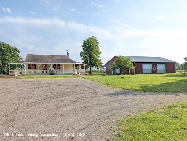 4963 E Portland Rd, Portland, MI 48875 - view of front of house with driveway, covered porch, a front lawn, an outdoor structure, and a detached garage