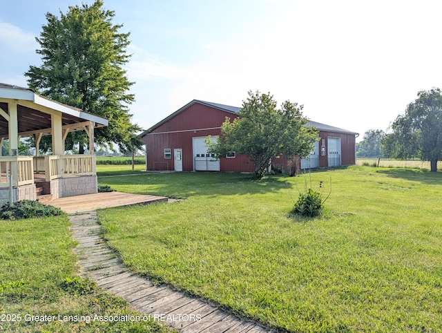 4963 E Portland Rd, Portland, MI 48875 - view of grassy yard featuring a detached garage and an outbuilding