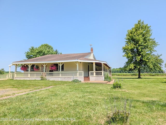 4963 E Portland Rd, Portland, MI 48875 - farmhouse featuring a porch, a chimney, and a front lawn