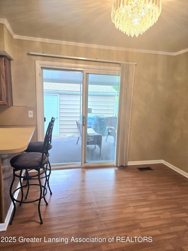 3701 Sumpter St, Lansing, MI 48911 - dining room with wood finished floors, a chandelier, and ornamental molding