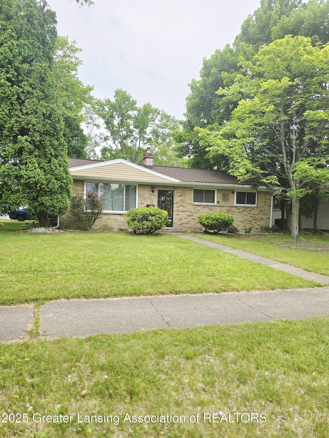 3701 Sumpter St, Lansing, MI 48911 - ranch-style house with a chimney, a front lawn, and brick siding