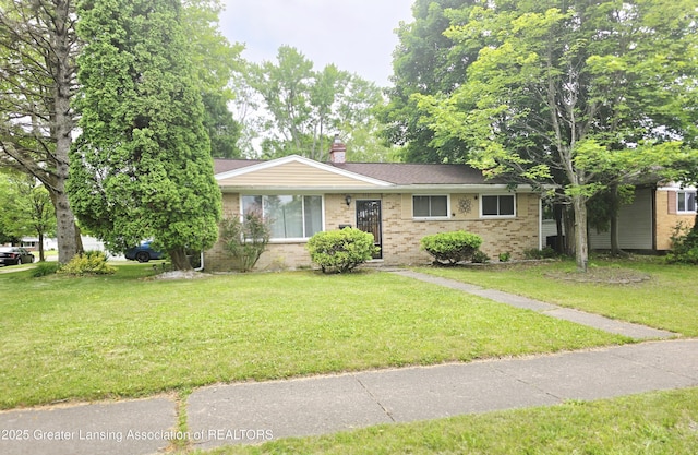 3701 Sumpter St, Lansing, MI 48911 - ranch-style house with brick siding, a front lawn, and a chimney