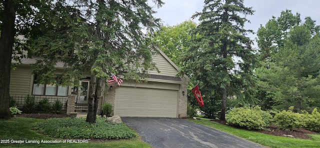 1945 W Danbury, Okemos, MI 48864 - obstructed view of property featuring driveway and brick siding