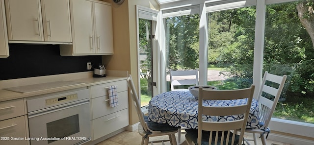 1945 W Danbury, Okemos, MI 48864 - kitchen featuring white oven, black electric stovetop, light countertops, range hood, and light tile patterned floors