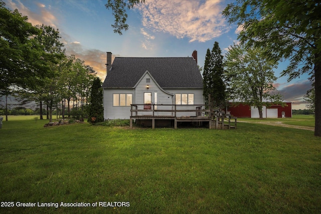 16544 S Chapin Rd, Elsie, MI 48831 - back of property at dusk with a chimney, a lawn, a deck, and an outdoor structure