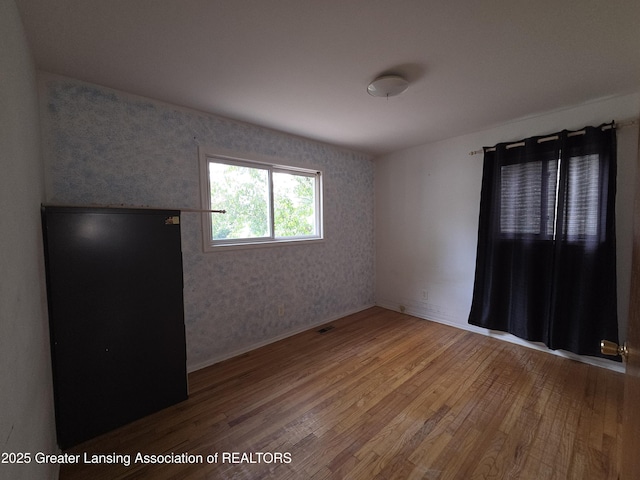 3629 Alpine Dr, Lansing, MI 48911 - unfurnished room with hardwood / wood-style floors and wallpapered walls