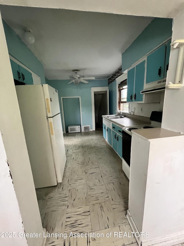 909 Baker St, Lansing, MI 48910 - kitchen featuring white appliances, under cabinet range hood, a ceiling fan, light floors, and light countertops
