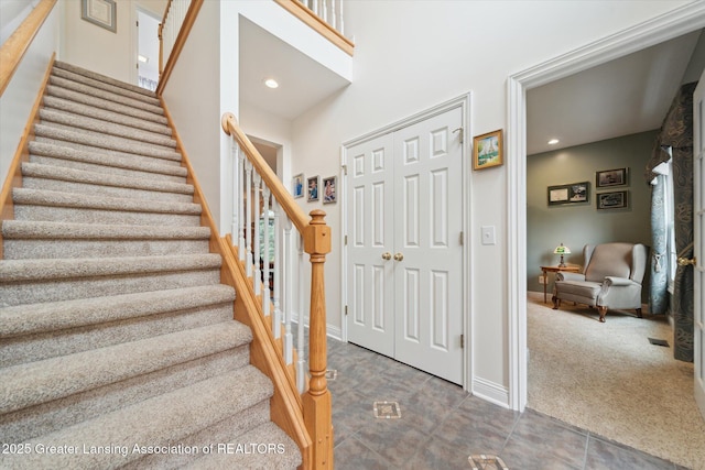 11195 Prestwick Dr, Lansing, MI 48917 - stairway with recessed lighting, carpet floors, tile patterned flooring, and a towering ceiling