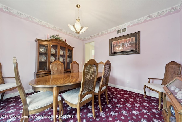 11195 Prestwick Dr, Lansing, MI 48917 - carpeted dining area featuring a chandelier and baseboards