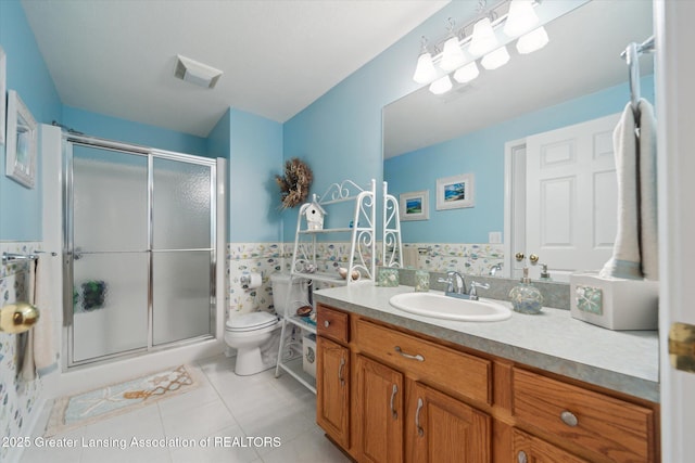 11195 Prestwick Dr, Lansing, MI 48917 - bathroom featuring vanity, a stall shower, tile patterned flooring, tile walls, and wainscoting