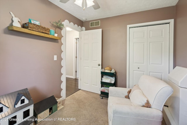 1539 Jacqueline Dr, Holt, MI 48842 - sitting room featuring a ceiling fan, carpet floors, and a textured ceiling