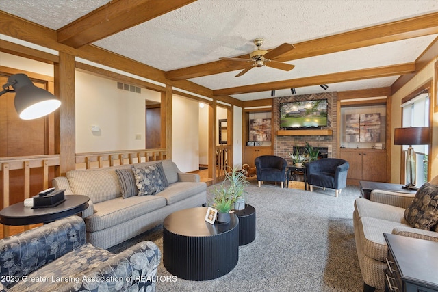 4925 Aspen Dr, Lansing, MI 48917 - living room with beam ceiling, ceiling fan, a brick fireplace, carpet floors, and a textured ceiling