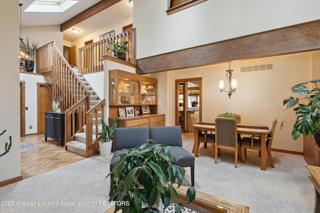 4925 Aspen Dr, Lansing, MI 48917 - dining space featuring a chandelier, stairs, high vaulted ceiling, and a skylight