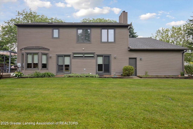 4925 Aspen Dr, Lansing, MI 48917 - rear view of property featuring a chimney and a lawn