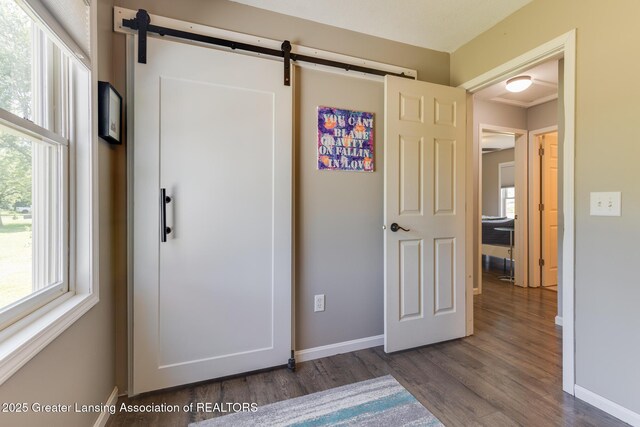 2520 Linn Rd, Williamston, MI 48895 - unfurnished bedroom featuring dark wood-style floors and a barn door