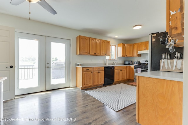 2520 Linn Rd, Williamston, MI 48895 - kitchen featuring appliances with stainless steel finishes, under cabinet range hood, wood finished floors, and light countertops