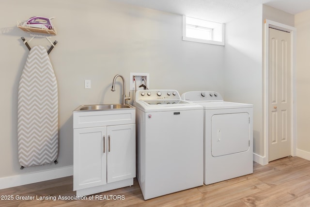 2520 Linn Rd, Williamston, MI 48895 - laundry room with washing machine and dryer, cabinet space, and light wood finished floors