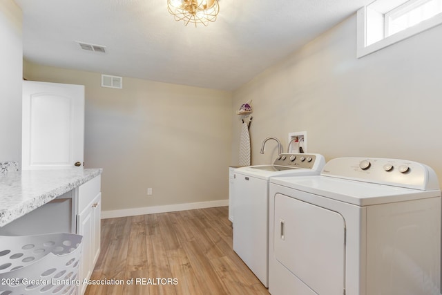2520 Linn Rd, Williamston, MI 48895 - washroom featuring independent washer and dryer, light wood-type flooring, and cabinet space