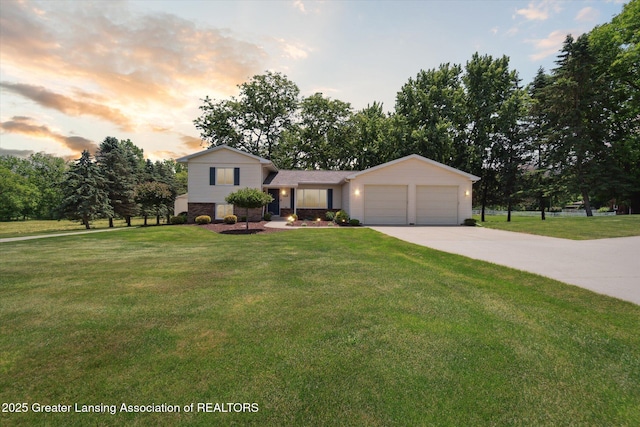 6252 N River Hwy, Grand Ledge, MI 48837 - split level home with concrete driveway, an attached garage, and a front yard