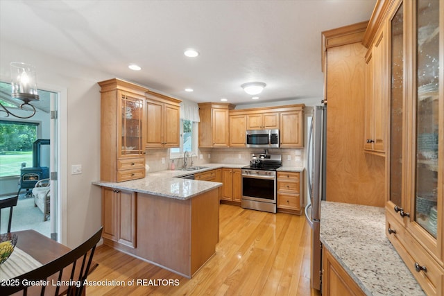 6252 N River Hwy, Grand Ledge, MI 48837 - kitchen featuring appliances with stainless steel finishes, a peninsula, plenty of natural light, tasteful backsplash, and recessed lighting