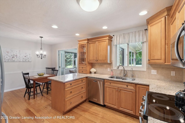 6252 N River Hwy, Grand Ledge, MI 48837 - kitchen with stainless steel appliances, a peninsula, light wood-style flooring, tasteful backsplash, and recessed lighting