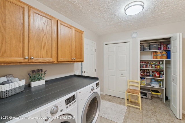 6252 N River Hwy, Grand Ledge, MI 48837 - laundry room featuring washing machine and clothes dryer, cabinet space, light tile patterned floors, and a textured ceiling