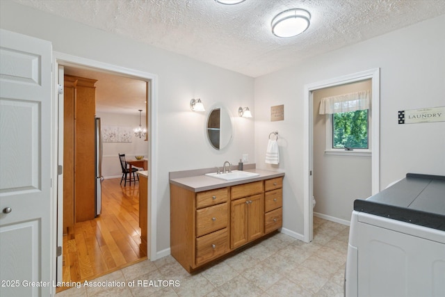 6252 N River Hwy, Grand Ledge, MI 48837 - bathroom featuring vanity, a textured ceiling, and a chandelier