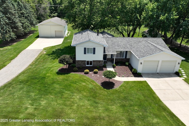 6252 N River Hwy, Grand Ledge, MI 48837 - tri-level home with a shingled roof, a front lawn, a garage, stone siding, and concrete driveway