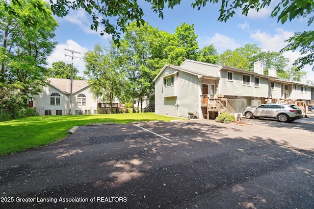 5041 E Willoughby Rd Unit 7, Holt, MI 48842 - view of front facade featuring uncovered parking, a chimney, and a front lawn