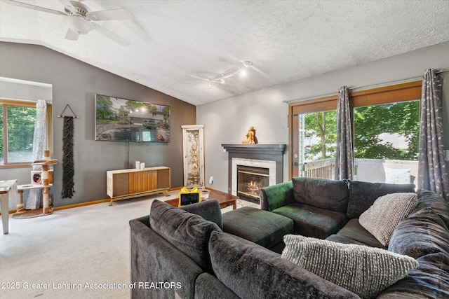 5041 E Willoughby Rd Unit 7, Holt, MI 48842 - carpeted living area with healthy amount of natural light, lofted ceiling, a fireplace, and a ceiling fan