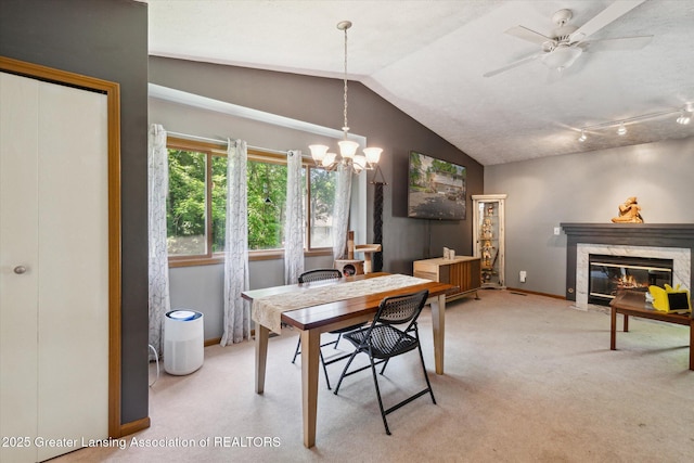 5041 E Willoughby Rd Unit 7, Holt, MI 48842 - dining space with vaulted ceiling, light colored carpet, a high end fireplace, and a chandelier