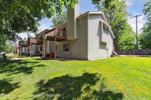5041 E Willoughby Rd Unit 7, Holt, MI 48842 - rear view of property with a chimney and a wooden deck