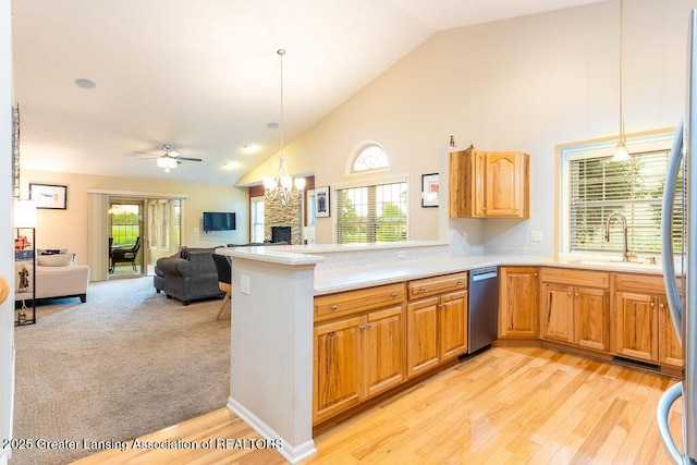 4001 Sierra Hts, Holt, MI 48842 - kitchen featuring appliances with stainless steel finishes, high vaulted ceiling, a stone fireplace, light countertops, and open floor plan