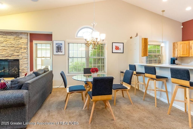 4001 Sierra Hts, Holt, MI 48842 - dining space featuring light colored carpet, a chandelier, high vaulted ceiling, and a fireplace