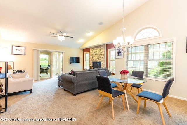 4001 Sierra Hts, Holt, MI 48842 - dining room featuring light colored carpet, a stone fireplace, healthy amount of natural light, a chandelier, and high vaulted ceiling